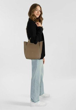 Sac fourre-tout en cuir taupe avec un design structuré, doté d'une longue sangle, d'une texture douce et d'une marque minimaliste à l'avant.