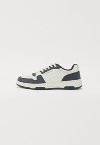 Zapatillas en azul marino y gris claro con parte superior de ante y cuero, lengüeta acolchada y diseño de cordones. Suela de goma con patrón de tracción.