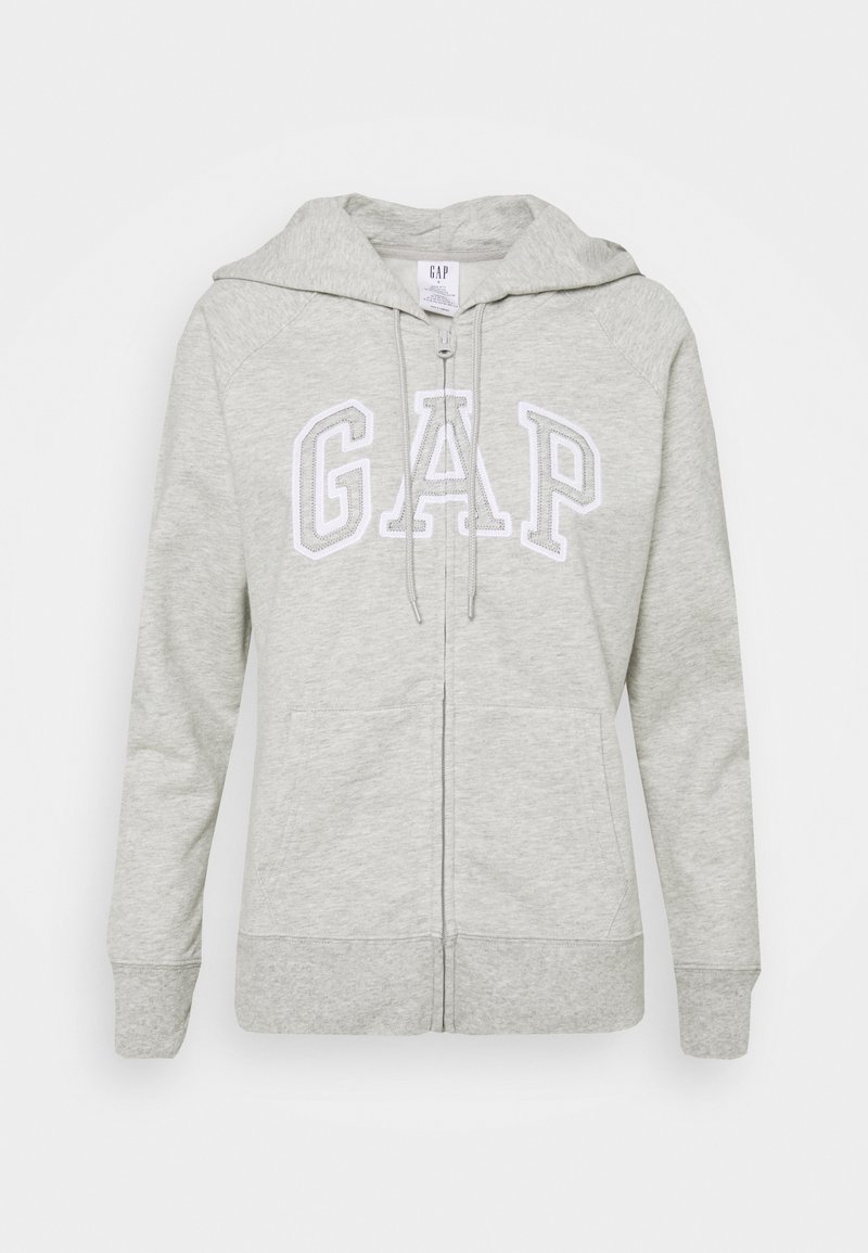 Felpa grigia con zip realizzata in morbido tessuto misto cotone. Presenta un cappuccio con coulisse, tasche frontali e il logo "GAP" in testo bianco sul petto.