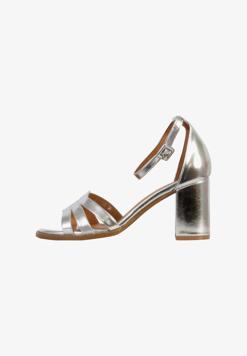 Zilverkleurige metallic sandaal met hakken, voorzien van kruislingse bandjes, een gesloten hiel en een chunky blokhak met een glad oppervlak.