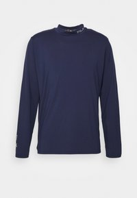 Mörkblå långärmad skjorta med hög krage och små "RLX"-logotyper på kragen och vänster ärm.