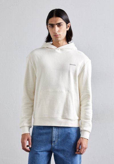 Hoodie couleur crème en tissu doux, doté d'une poche frontale, de poignets côtelés et d'une capuche à cordon. Logo de marque discret sur la poitrine.