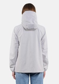 Giacca impermeabile grigio chiaro con cappuccio, polsini elastici e vestibilità comoda. Texture liscia, design minimalista, senza loghi o motivi visibili.