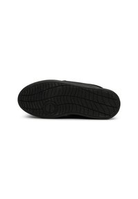 Suola in gomma nera di una sneaker con un motivo a trama testurizzata e un dettaglio centrale a forma di logo circolare. Design pulito e minimale.