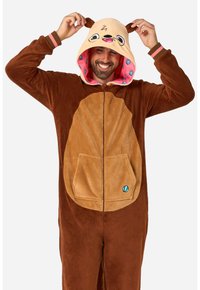 Tutina in pile marrone con cappuccio a forma di orsetto beige, caratterizzata da occhi e orecchie da cartone animato. Zip anteriore con tasca e dettaglio decorativo a forma di conchiglia.
