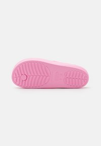 Suola di scarpa in gomma rosa con motivi di presa testurizzati e un dettaglio a forma di pulsante circolare. Finitura liscia con bordo curvato e punta arrotondata.