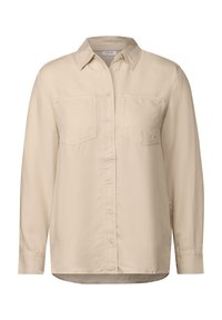 Camisa beige de botón con cuello, de manga larga y dos bolsillos en el pecho. Fabricada en material suave con una textura lisa. Corte recto.