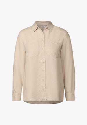 Beżowa koszula zapinana na guziki z kołnierzykiem, długim rękawem i dwiema kieszeniami na piersi. Wykonana z miękkiego materiału o gładkiej fakturze. Prosty dół.