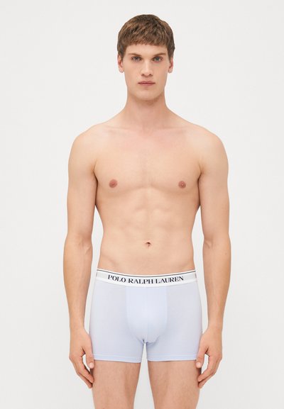 Moške bokserice v svetlo modrem materialu z oprijetim dizajnom. Imajo kontrastno belo elastiko z napisom "POLO RALPH LAUREN".