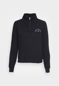 Svart sweatshirt med hög krage och halvdragkedja. Har ribbade muddar och nederkant, med "HOLLISTER"-logotyp i vitt på bröstet. Mjuk textur.