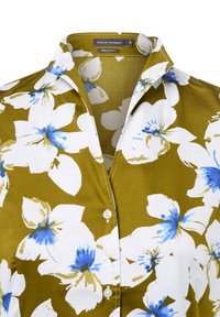 Blusa a maniche corte di colore verde oliva con un motivo floreale bianco e blu. Presenta un colletto a punta e chiusura con bottoni, realizzata in tessuto leggero.