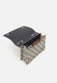 Bolsa de tela texturizada con un exterior de patrón azul y crema, interior negro y herrajes plateados; cuenta con un cierre con solapa y un bolsillo interior visible.