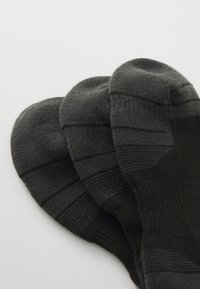 Tres calcetines gris oscuro con textura de canalé, que presentan sutiles rayas horizontales. El diseño es sin costuras y tiene las zonas de los dedos redondeadas.