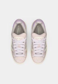 Αθλητικά παπούτσια από σουέτ σε ανοιχτό μωβ χρώμα με κρεμ λεπτομέρειες, με τρεις γραμμές στη πλευρά, κορδόνια και υφασμένο λαστιχένιο πέλμα. Λογότυπο στη γλώσσα.