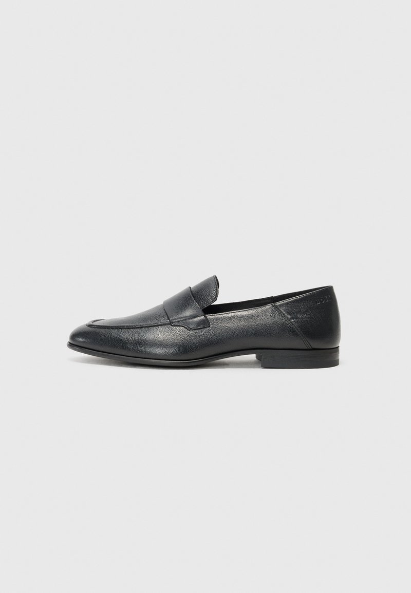 Black leather loafer shoe with a smooth texture, low heel, and a slip-on design featuring a raised seam across the front.