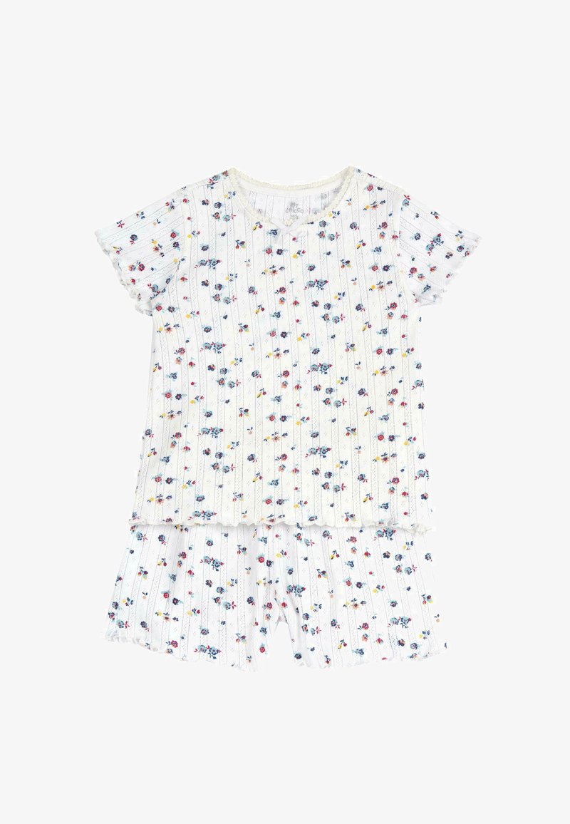 Ensemble de pyjama floral en blanc, présentant des manches courtes et des ourlets volantés. Le haut a un col rond avec un motif de petites fleurs colorées.