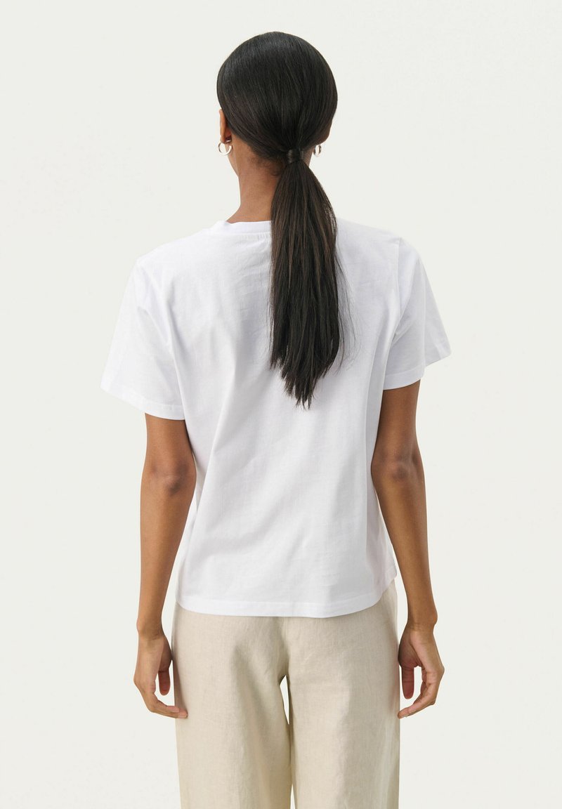 Weißes Baumwoll-T-Shirt mit lockerer Passform, kurzärmelig und mit Rundhalsausschnitt. Glatte Textur und minimalistisches Design.