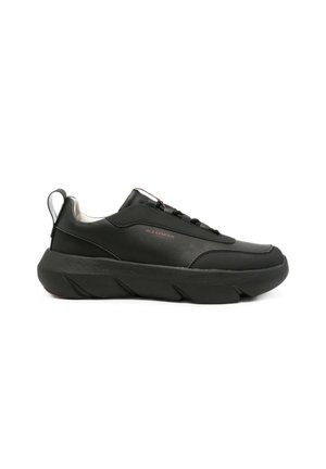 Sneaker nero low-top con suola spessa scolpita e design con lacci, mostra il profilo laterale con un marchio discreto "Alexander" sul lato esterno.