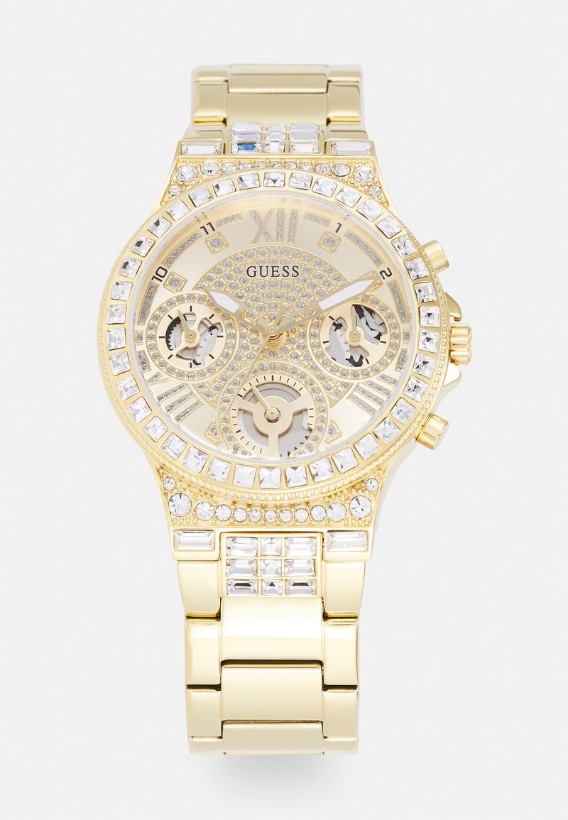 Montre Guess dorée avec un cadran texturé, un bezel orné de cristaux scintillants et des sous-cadrans chronographes. Bracelet en maillons métalliques avec une finition brillante.