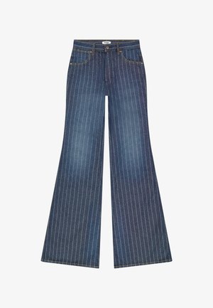 Μπλε τζιν καμπάνα με κάθετες λευκές διακεκομμένες ρίγες, μπροστινές τσέπες, θηλιές ζώνης και ετικέτα Wrangler στη ζώνη μέσης.