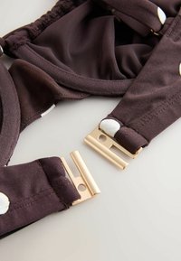 Pruun kangast bralette valgete täppidega; varustatud kuldsete metallklambritega, reguleeritavate rihmade ja pehme tekstuuriga voodriga.