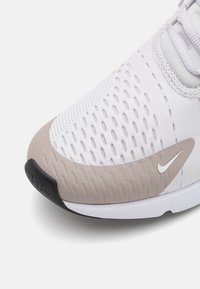 Lagani, prozračni tenisice od bijele mrežice s bež naglascima. Imaju teksturiranu gumenu potplat i suptilni Nike logo u bijeloj boji.