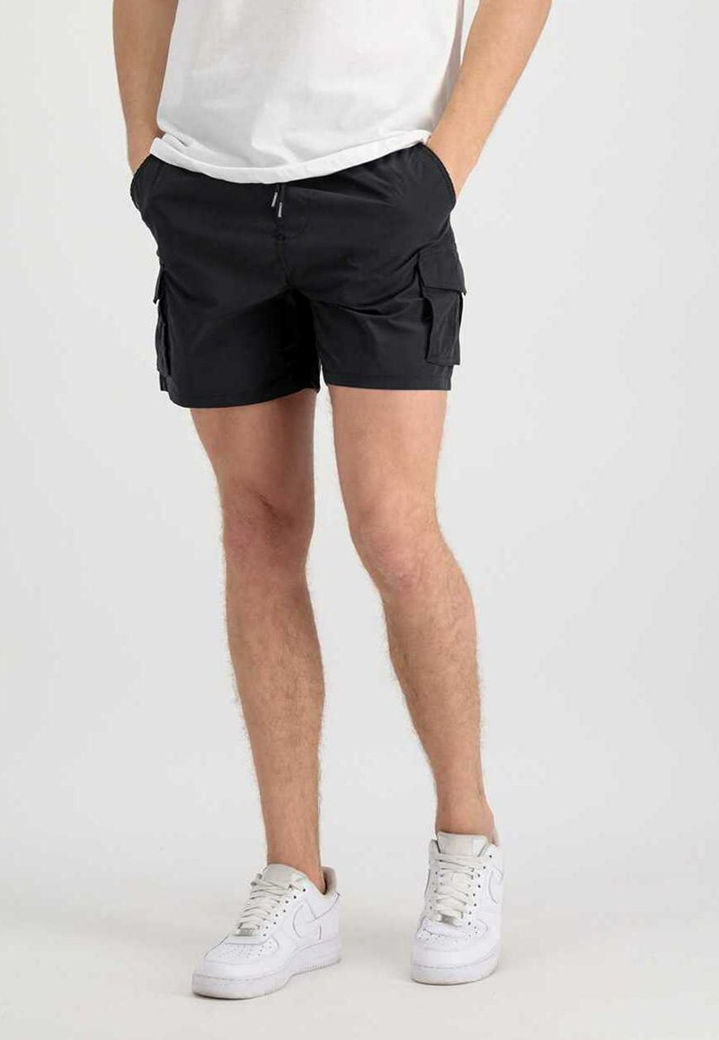 Black cargo shorts in a lightweight material with side pockets and an elastic waistband, paired with white sneakers.