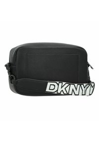 Borsa a tracolla nera in pelle con chiusura a zip, forma rettangolare e ampia tracolla bianca con logo "DKNY" in lettere maiuscole.