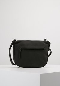 Schwarze Umhängetasche aus glattem Stoff. Verfügt über eine vordere Reißverschlusstasche und einen verstellbaren Träger. Abgerundete Form mit minimalistischem Design.