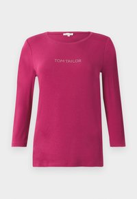 Fuksijaste srajce z dolkimi rokavi in okroglo ovratnikom ter napisom "TOM TAILOR" iz kamenčkov čez prsi. Mehka bombažna tkanina.
