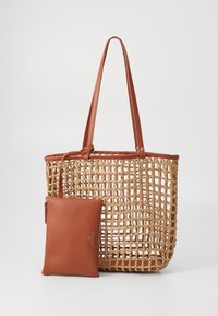 Bolso de paja tejido con acentos y asas de imitación cuero marrón. Incluye un pouch de cuero marrón extraíble con un logo dorado.