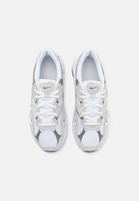 Scarpe sportive bianche e grigie con tomaia in mesh, suola in gomma e accenti testurizzati. Presentano una tradizionale allacciatura e un logo sulla linguetta.