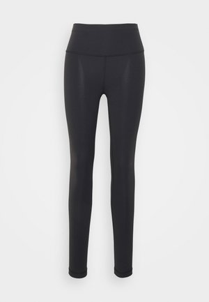 Black leggings made from stretchy fabric, featuring a high waistband, form-fitting design, and seamless construction, suitable for active wear.