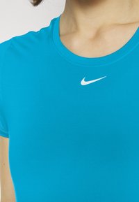 Blå idrottströja i glatt tyg, med rund halsringning och korta ärmar. Nike-logotypen syns i vitt.