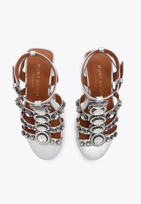 Srebrne sandały na obcasie z wieloma paskami ozdobionymi cyrkoniami i teksturowanym wykończeniem ze skóry; brązowe wkładki z detalem logo.