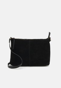 Borsa a tracolla in suede nero con zip dorata e tracolla regolabile su sfondo bianco uniforme.