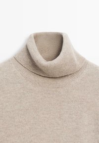 Maglione beige a collo alto realizzato in morbido materiale a maglia. Presenta una texture a costine sul colletto e sull'orlo, con un design classico a vestibilità Slim.