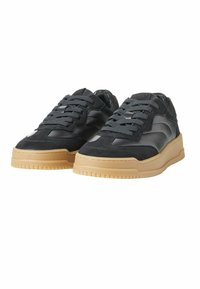 Sneaker neri in pelle e suede, con suola in gomma spessa, punta rotonda e lacci elastici per una calzata sicura.