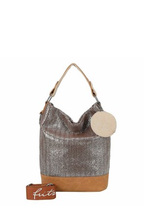 Sac fourre-tout argenté métallique avec fond en cuir beige, petite pochette ronde pailletée beige, et bandoulière amovible marron avec texte en écriture blanche.