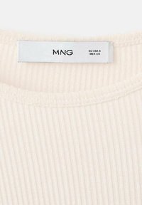 Cremfarbener, gerippter Tanktop mit rundem Ausschnitt. Zeigt ein Etikett mit "MNG" und Größeninformationen. Weicher Stoff und subtiles Muster.