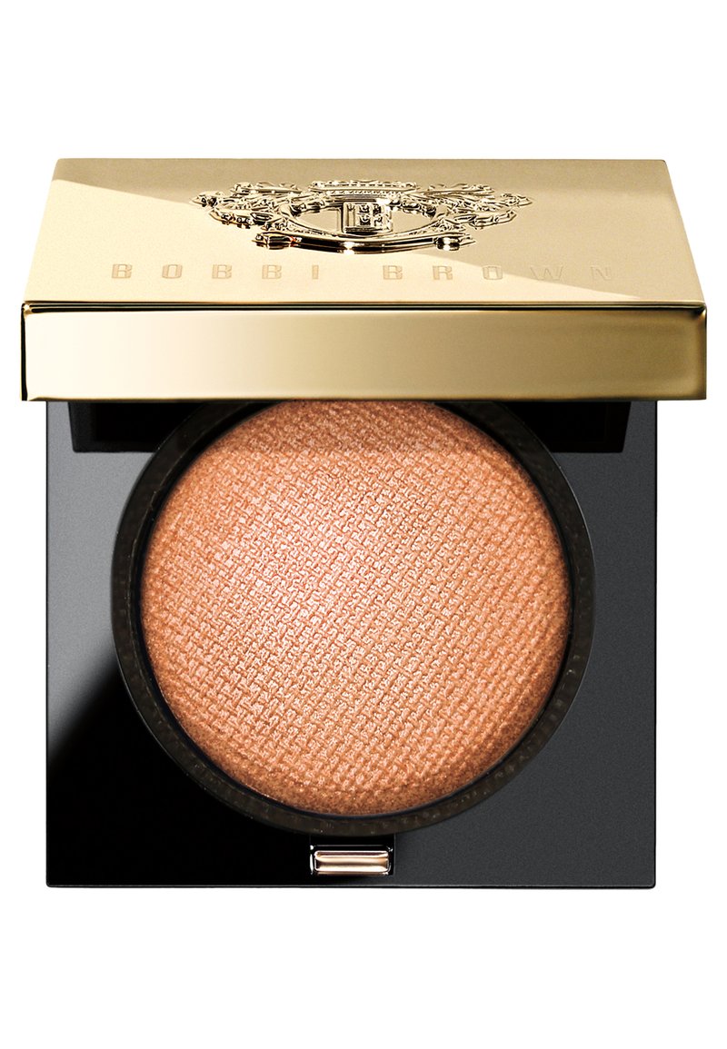 Bobbi Brown highlighter in een zwarte compacte. Beschikt over een gemarmerd champagnekleurig poeder, afgewerkt met een gouden deksel met het logo erin gedrukt.