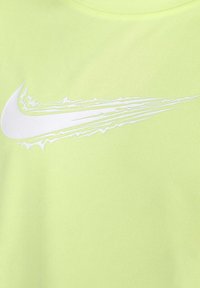 T-shirt Nike verde lime con logo swoosh bianco e accenti striati. Il tessuto ha una finitura testurizzata e traspirante.