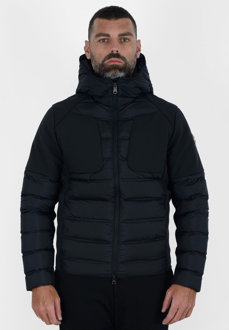 Giubbotto piumino nero con design trapuntato, caratterizzato da un alto colletto, chiusura con zip e doppie tasche frontali. Tessuto morbido e forma aderente.