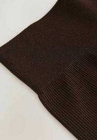 Hnědá jemně žebrovaná látka s hladkým povrchem, zakřivenými okraji a přizpůsobeným designem, s jemnými rýhami pro dodatečnou dimenzi.