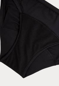 Svart högmidjad underkläder tillverkad av ett slätt, stretcht fabric; har förstärkta sömmar och en kontrasterande matt yta på ena sidan.