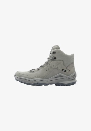 Lichtgrijze wandelschoen van gemiddelde hoogte met veters aan de voorkant, geperforeerd zijpaneel, Gore-Tex-label en robuuste buitenzool voor grip.