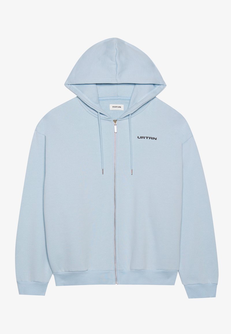 Felpa con zip di colore blu chiaro realizzata in tessuto morbido, con un ampio cappuccio, polsini e orlo a costine, e la scritta "URTRN" stampata sul petto.