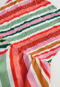 Tela de algodón multicolor con rayas diagonales en rojo, rosa, verde, naranja y blanco, con una apariencia texturizada y arrugada.