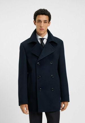 Marineblaues Wollmischgewebe-Peacoat mit einem doppelt geknöpften Design, großen Revers und schwarzen Knopfakzenten. Glatte Textur, knielange Schnittform.