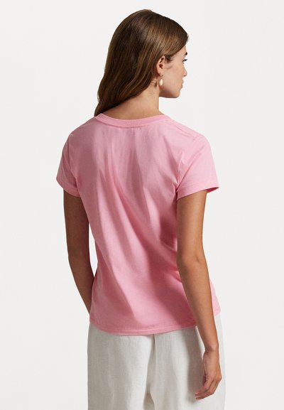 T-shirt rose à manches courtes en coton, avec un col rond et une coupe décontractée, affichant une texture lisse et des coutures minimales.